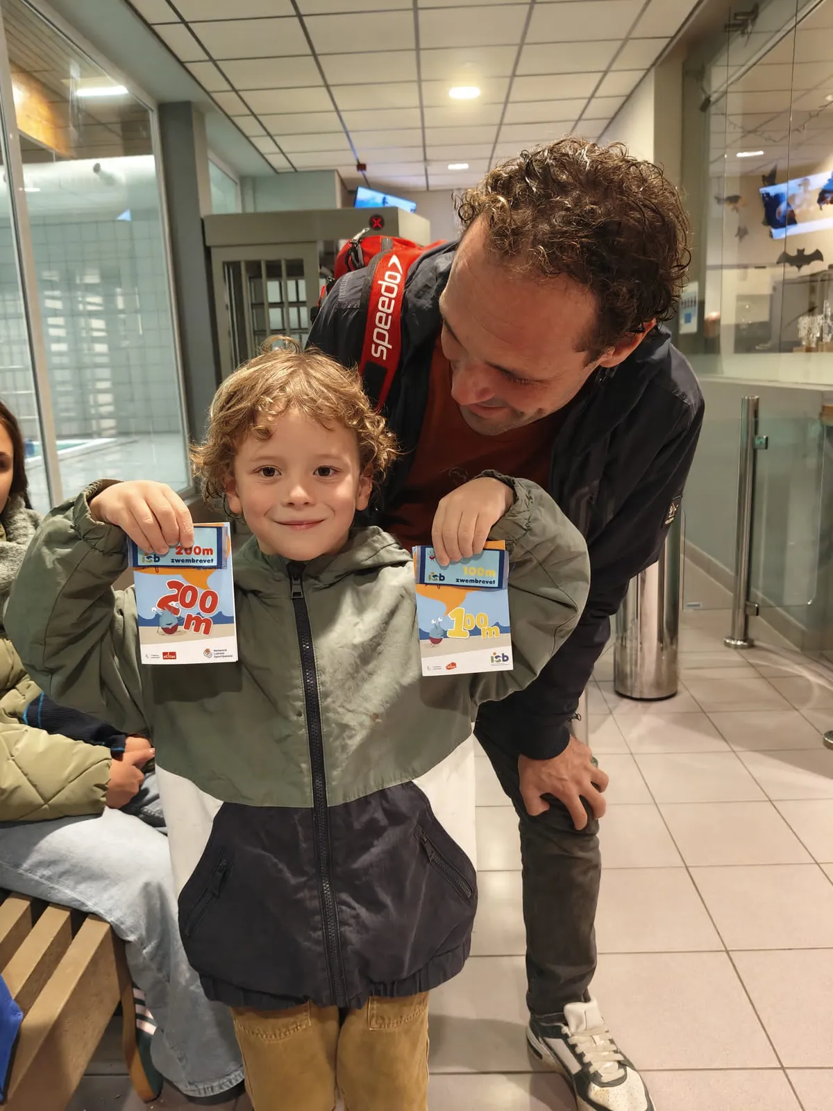Klaas met een jongen die zijn brevetten van 200 meter toont